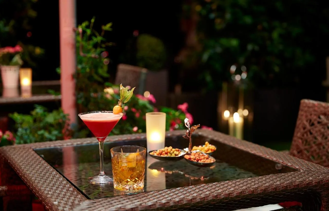 a table with two drinks and a candle on it at The Royal Horseguards Hotel, London in London